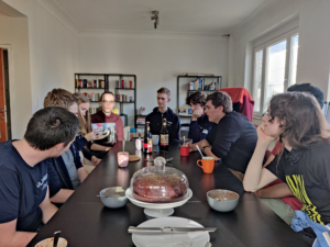 ULYSSIS-leden rond een tafel waar taart klaarstaat om uitgedeeld en opgegeten te worden